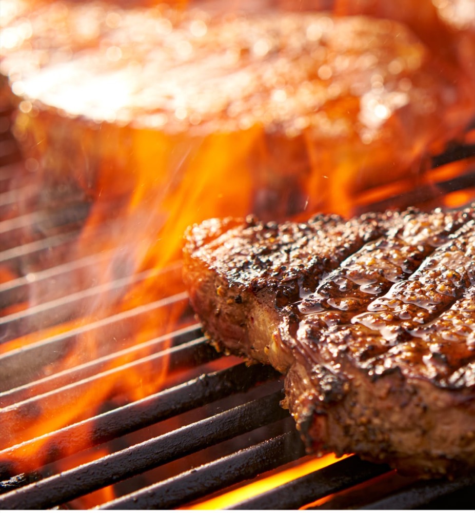 Steaks searing over open flame